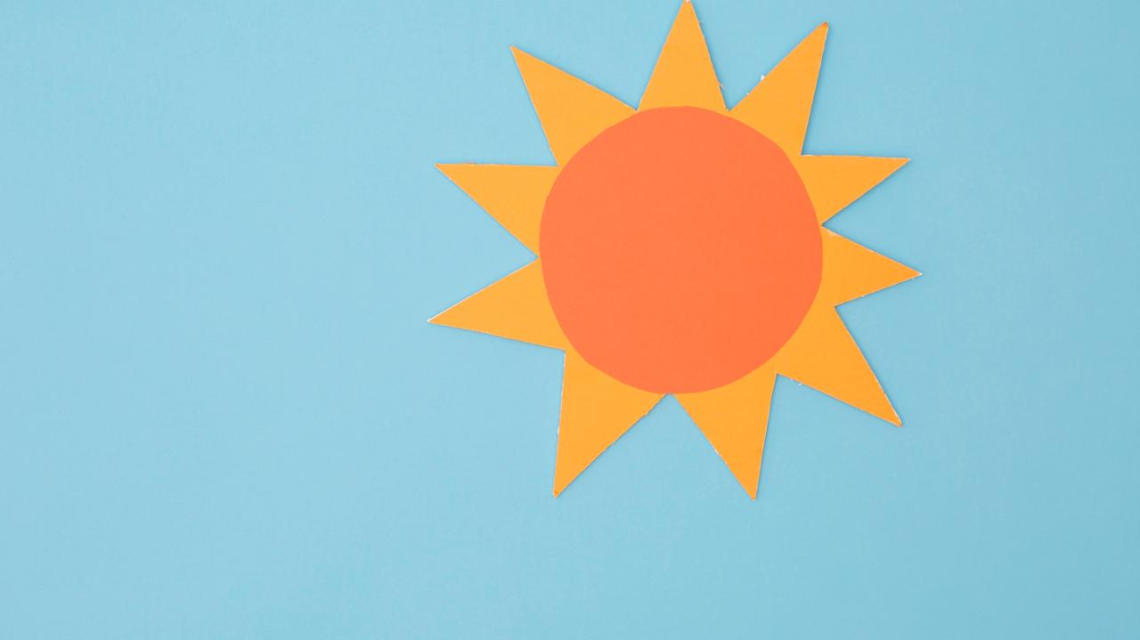 Sole di carta arancione su sfondo azzurro